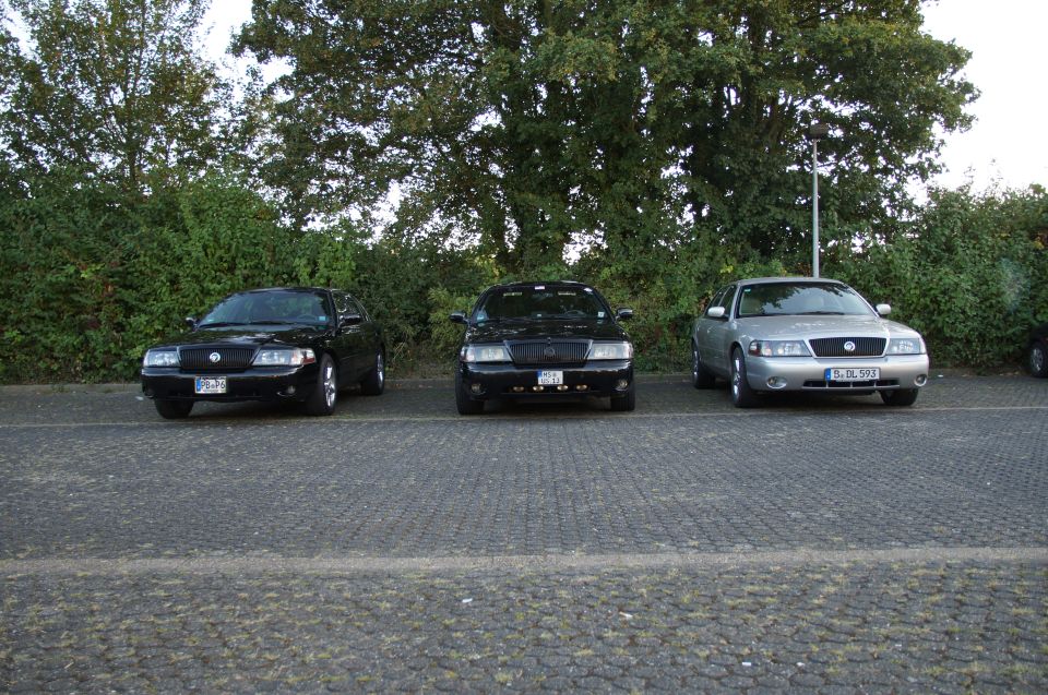Three sedans parked in a lot.