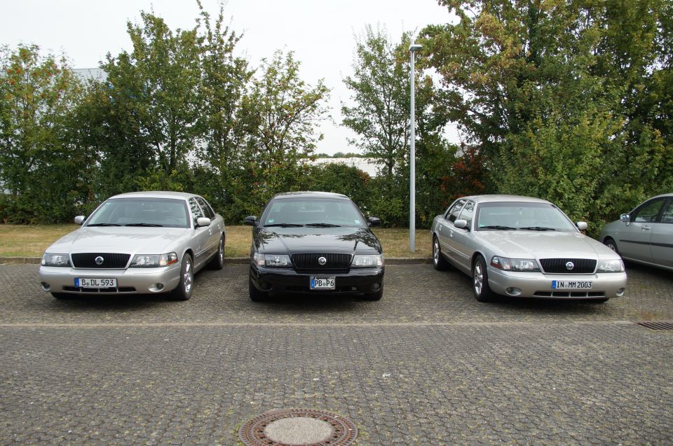 Three 2003 Mercury Marauders parked in a lot, two silver and one black