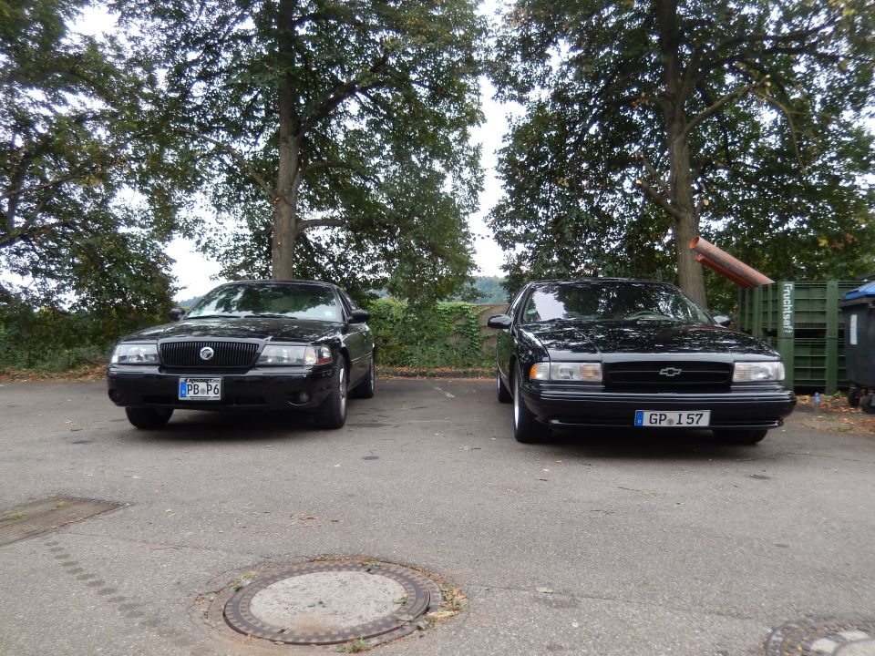 Two black sedans parked side-by-side, one is a 2003 Mercury Marauder with a PB P6 license plate