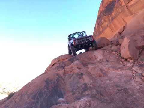 1979 Ford Bronco - A 1979 Ford Bronco navigates a challenging rocky ascent in a desert landscape.