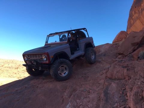 1979 Ford Bronco - This modified Ford Bronco navigates a challenging off-road path in a desert landscape.