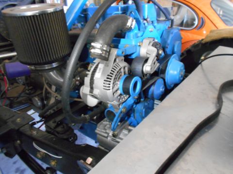 1992 Ford Bronco - Close-up view of an engine bay a blue engine block, silver alternator, and an air filter assembly.