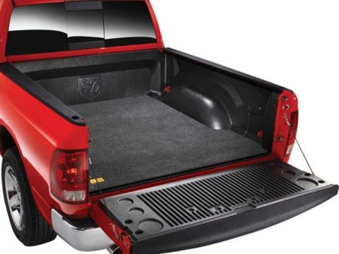 2001 Ford Ranger - Rear view of a red pickup truck's bed, a protective liner and an open tailgate. The Ram logo is embossed on the bed liner.