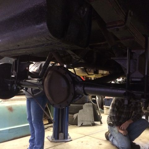1962 Chevrolet Suburban - Underside view of a vehicle's rear axle and suspension system during maintenance.