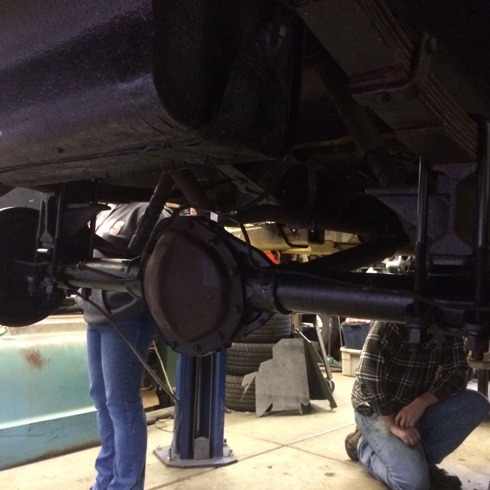 Rear axle assembly and leaf springs on a vehicle lifted for service
