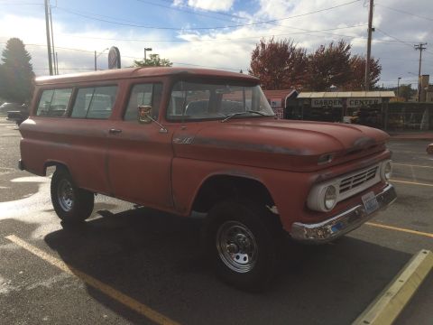1962 Chevrolet Suburban - This 1962 Chevrolet Suburban is parked in a lot, showing its distinctive grille and body style.