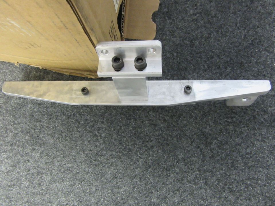 Aluminum bracket with two bolts attached to a larger aluminum piece