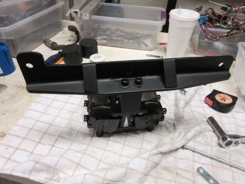 Black car part with mounting brackets and bolts