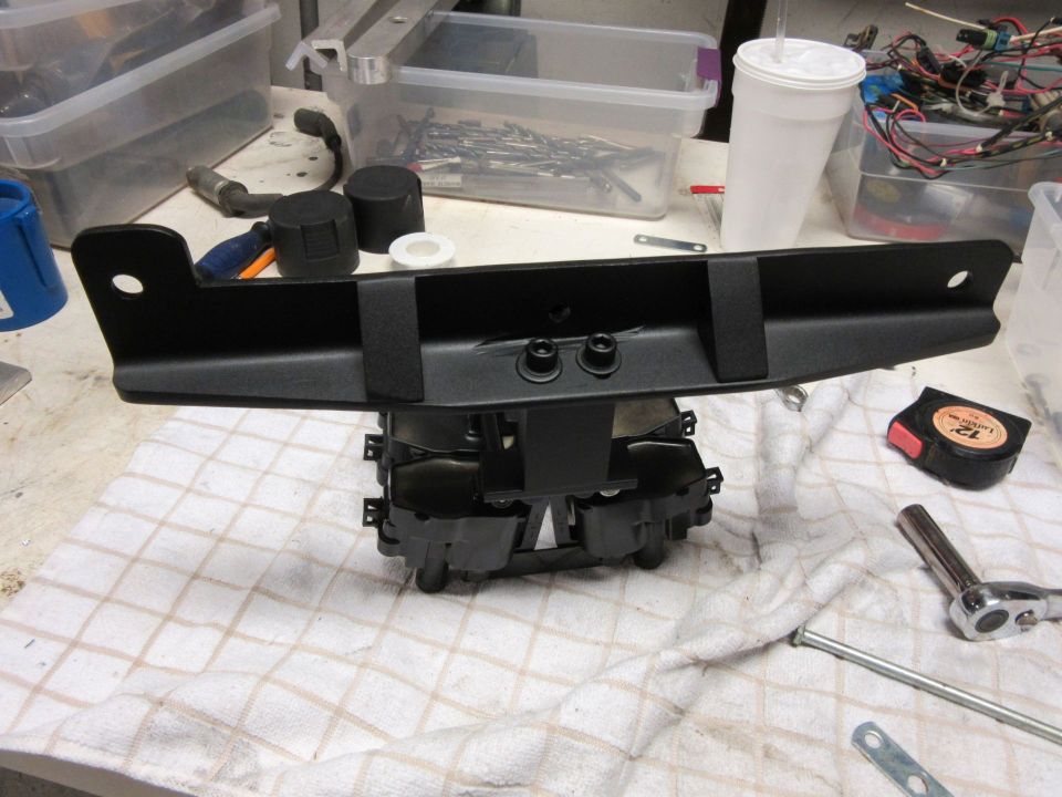 Black car part with mounting brackets and bolts