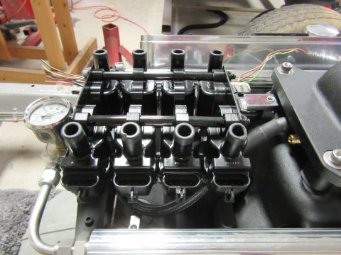 Engine ignition coils with wiring and a pressure gauge attached to a manifold
