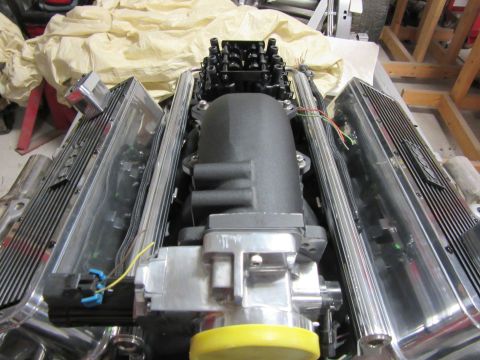 Close-up of a V8 engine with chrome valve covers and a black intake manifold