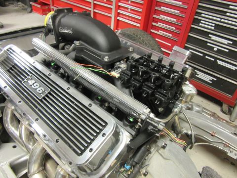 Engine block with "496" inscribed on a chrome valve cover, black intake manifold, and exposed wiring