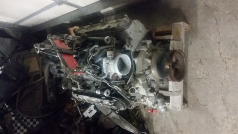 1987 Toyota 4Runner - Engine assembly with red accents and visible hoses and components is shown on wooden pallets.