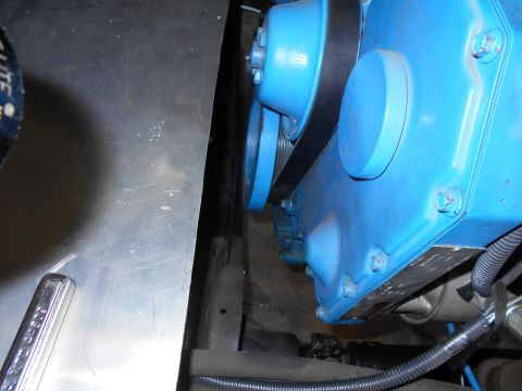 1992 Ford Bronco - Close-up of a blue engine component with a drive belt and pulleys, viewed from an engine bay.