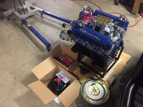 1982 Ford Bronco - A blue Ford Racing V8 engine is shown with a torque converter and flywheel, ready for installation.