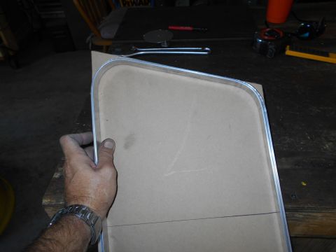 1992 Ford Bronco - A person is holding a cardboard template with a metal edge, marked with pencil lines.