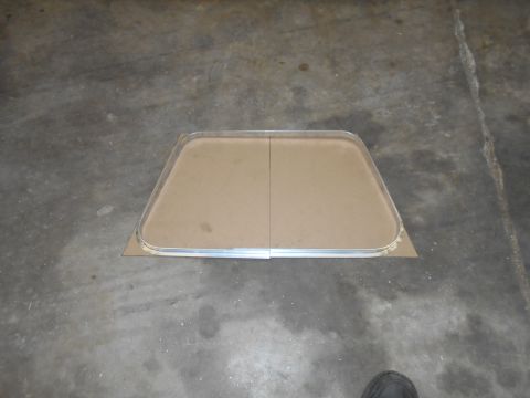 1992 Ford Bronco - A metal window frame is shown on a concrete surface, backed by cardboard.