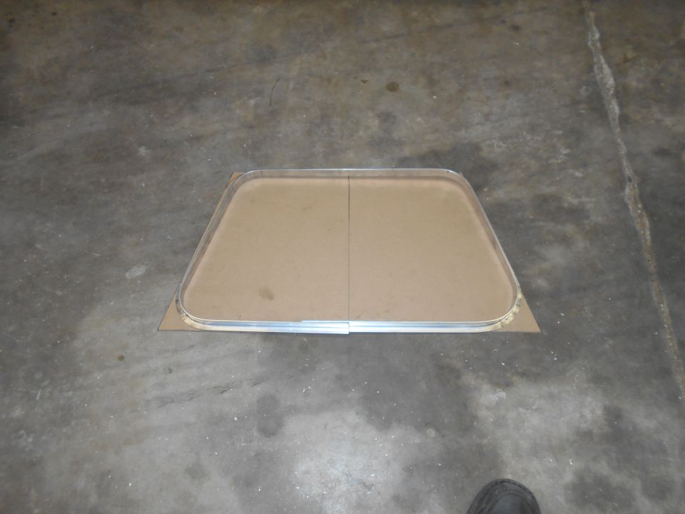 Window frame with cardboard backing on concrete floor