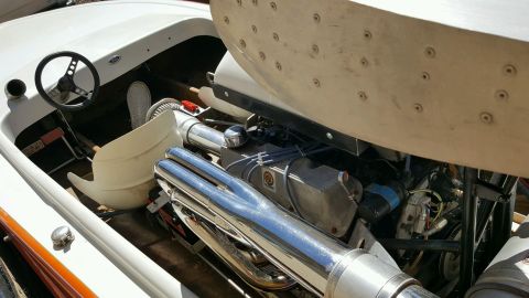 1970 Ford Five Hundred - Close-up view of a boat's engine compartment and cockpit area, showing the steering wheel and chrome exhaust.