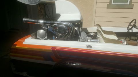 1970 Ford Five Hundred - This boat features a powerful engine with chrome exhaust headers and a striped hull design.