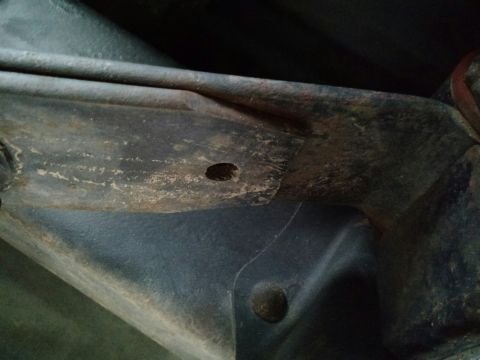 1992 Ford Bronco - Detail of a vehicle's undercarriage, showing a rusty leaf spring mount.