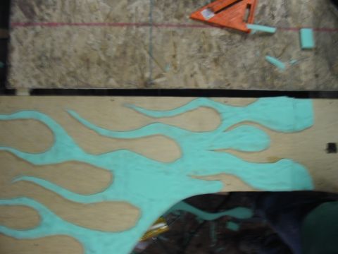 1981 Ford Bronco - Teal flame graphic on wood panel, with an orange speed square visible.