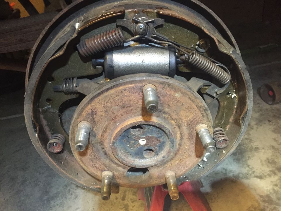 Drum brake assembly with wheel cylinder, springs, and brake shoes visible