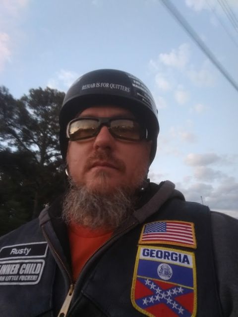 2014 Harley-Davidson FXDWGI Wide Glide - A man wearing a helmet and a vest with various patches, including an American flag and 'Georgia', poses for a selfie.