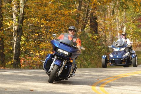 2014 Harley-Davidson FXDWGI Wide Glide - A motorcycle and a three-wheeled vehicle ride on a scenic road during the fall season.