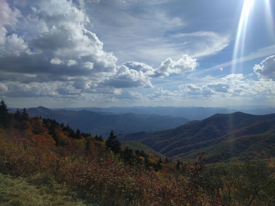 Mountain range under a cloudy sky with sunbeams