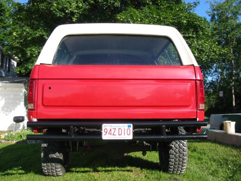 1981 Ford Bronco - This 1981 Ford Bronco is shown from the rear, a red body, white removable top, and a black aftermarket bumper.