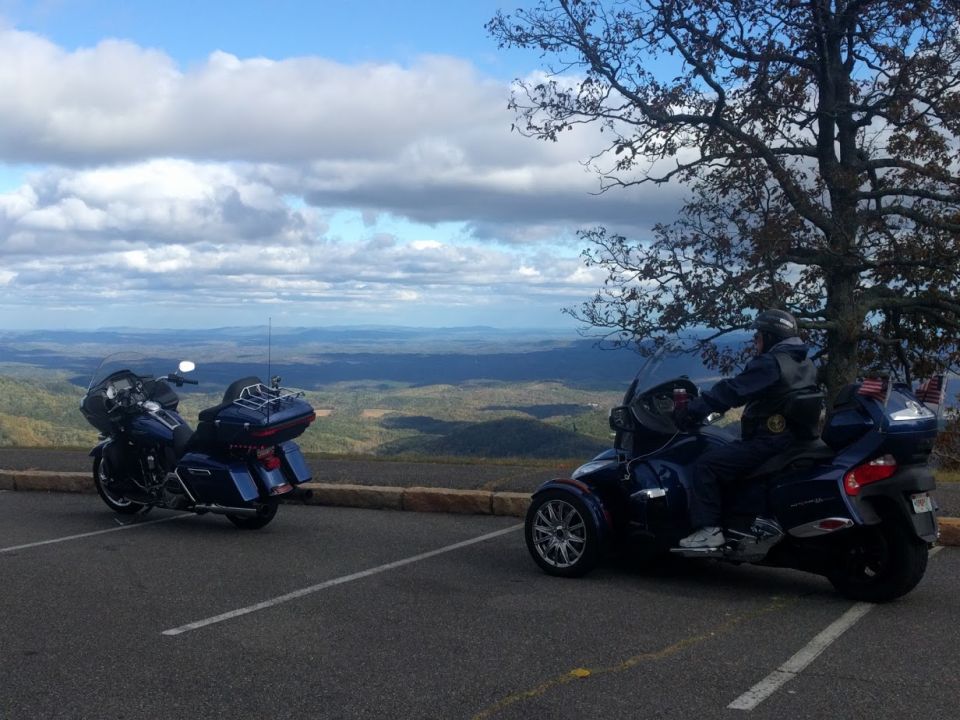 two touring motorcycles parked at an overlook with a scenic mountain view