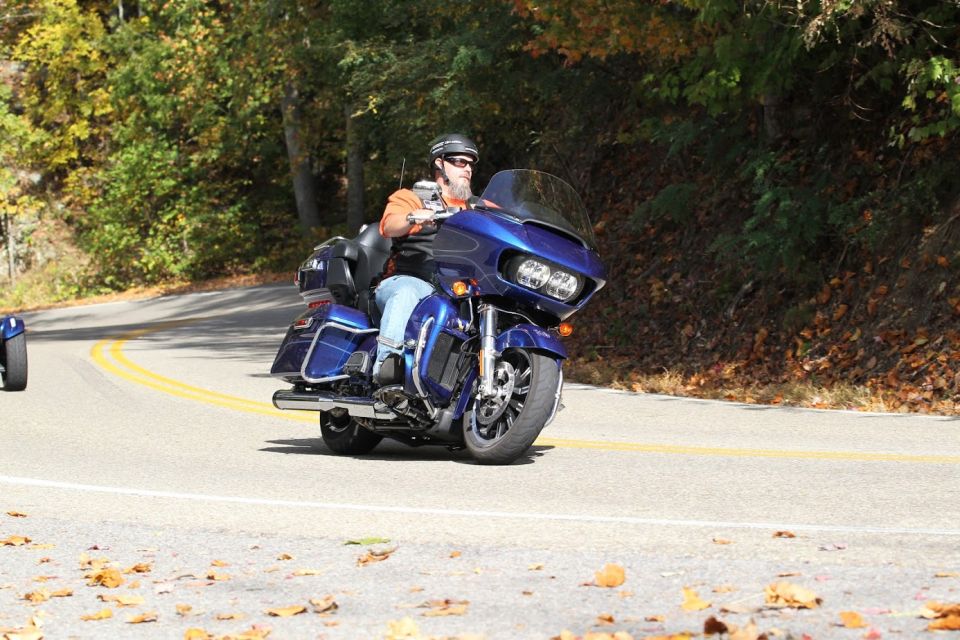 Blue Harley-Davidson motorcycle with a large windshield and saddlebags on a winding road