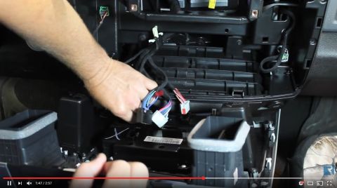 2000 Ford Crown Victoria - A person is shown connecting wires inside a vehicle's dashboard area.