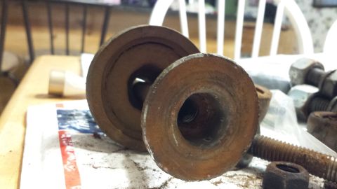 1976 Ford Ranchero - Close-up of corroded metal components, likely automotive parts, resting on a surface.