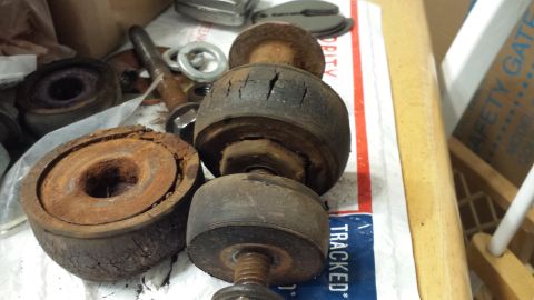 1976 Ford Ranchero - Several heavily rusted suspension bushings and associated hardware are laid out on a surface.