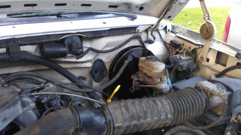 1994 Ford Bronco - The engine bay of a 1994 Ford Bronco is shown, with the hood open. Visible components include the brake master cylinder, air intake, and va…