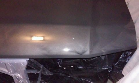 1986 Ford Bronco - A close-up, low-angle shot of a dark-colored vehicle's interior ceiling panel, possibly a headliner, with a rectangular light fixture illum…
