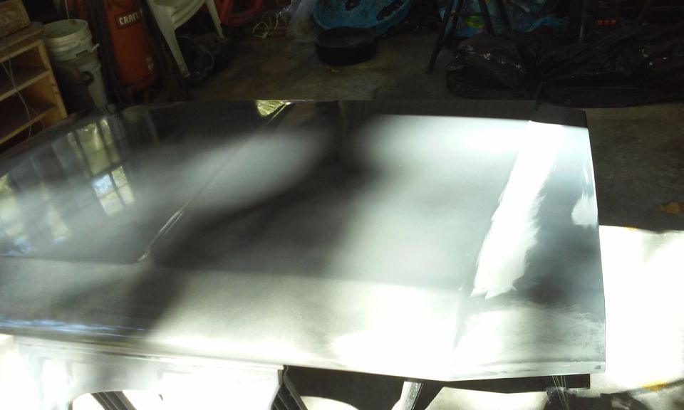 Vehicle hood in a garage, prepped for paint.
