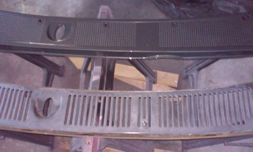 Two dark vehicle cowl grilles, one above the other, with cutouts and textured or slatted surfaces.