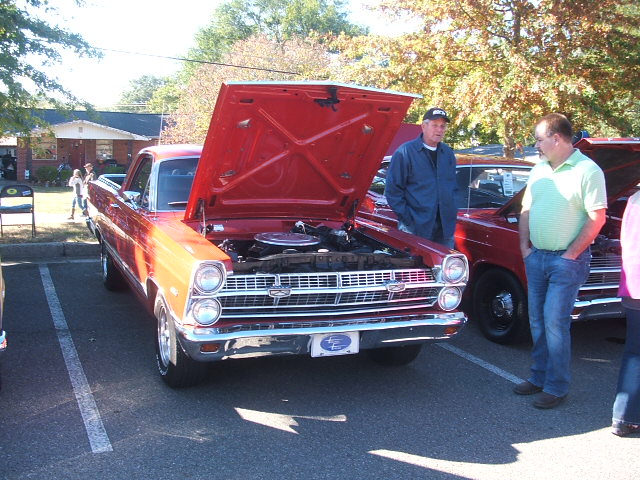 Red 1972 Ford Ranchero with hood open, two men looking at engine.