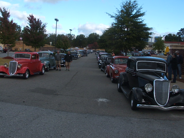 Line of vintage cars parked on a street.