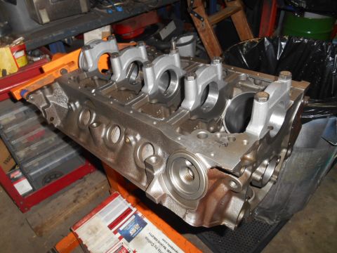 1972 Ford Bronco - A disassembled engine block with connecting rods installed is shown in a workshop setting. The engine block is made of cast iron and has a…