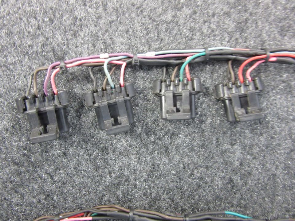 Wiring harness with black connectors and multi-colored wires.