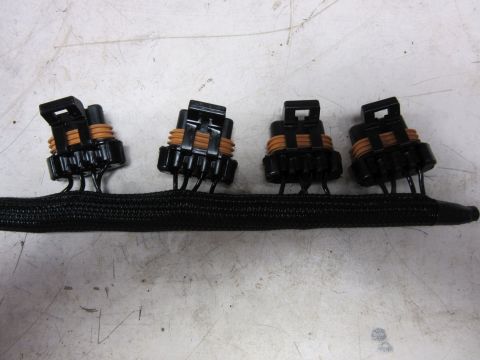 Black braided wire harness with four black electrical connectors with orange seals.