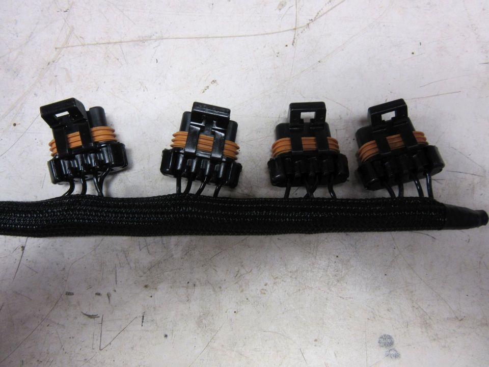 Black braided wire harness with four black electrical connectors with orange seals.