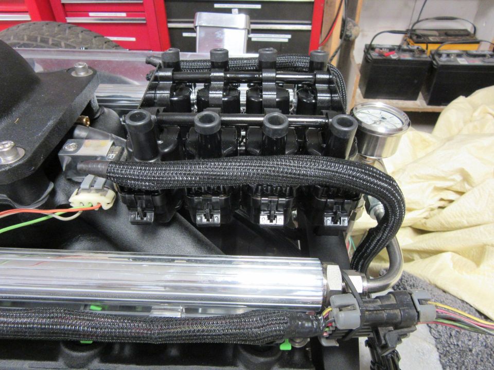Engine intake manifold with fuel rails, ignition coils, and pressure gauge.