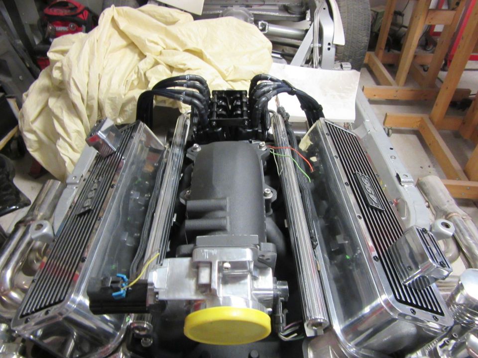 Overhead view of a V8 engine with polished valve covers and chrome headers.