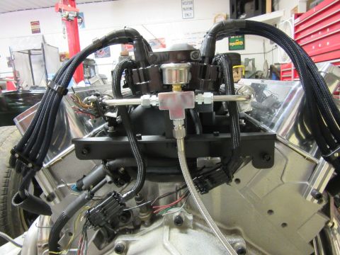 1976 Chevrolet Corvette engine bay with polished valve covers and braided fuel lines.