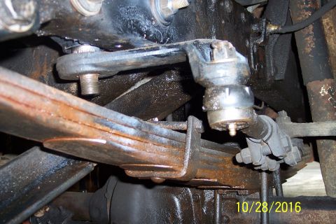 1973 Ford F-250 - A close-up view of the steering linkage and leaf springs of a vintage Ford truck, showing significant wear and grease.